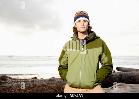 Portrait of young, outdoorsy man in jacket and hat while hiking at La Push Beach, Washington. Stock Photo