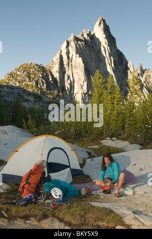 A woman camping below Prussik Peak, Enchantment Peaks, Alpine Lakes Wilderness, Leavenworth, Washington. Stock Photo