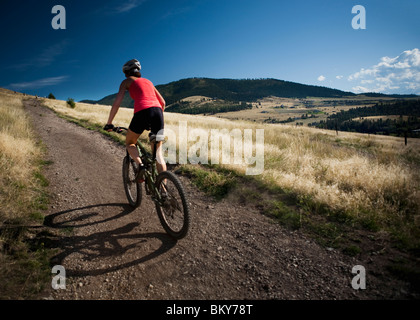 A female mountain biker pedals the trail on Mt. Sentinel, Missoula, Montana. Stock Photo
