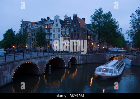 Boat, Keizersgracht, Leidsegracht, A leisure boat passing a stonebridge during a sightseeing tour in the evening, Keizersgracht Stock Photo