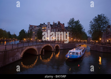 Boat, Keizersgracht, Leidsegracht, A leisure boat passing a stonebridge during a sightseeing tour in the evening, Keizersgracht Stock Photo