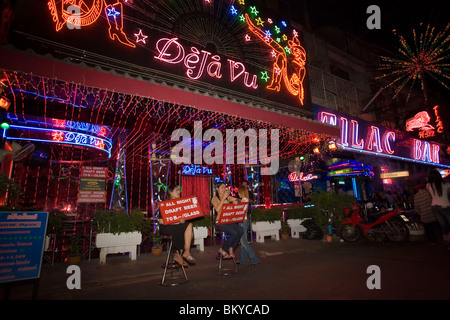Women sitting in front of Go-go bar 'DeJa Vu' and presenting signs, Soi Cowboy, a red-light district, Th Sukhumvit, Bangkok, Tha Stock Photo