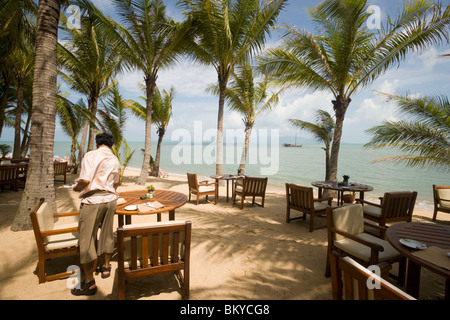 Waiter setting the table in the beach restaurant of the Santiburi Dusit Resort, Mae Nam Beach, Hat Mae Nam, Ko Samui, Thailand Stock Photo