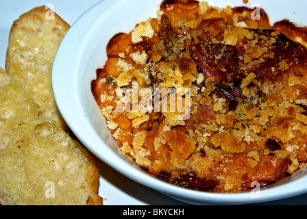 Oven baked buttered bread crumb crusted duck confit white bean cassoulet with garlic French bread toast Stock Photo