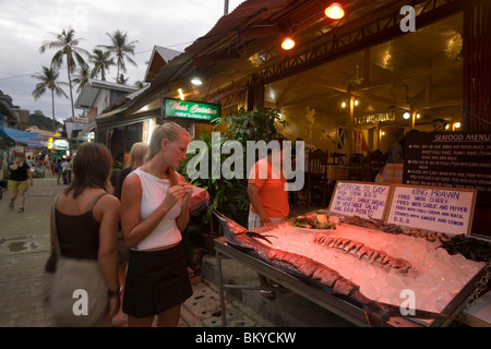 Two women in front of a fish restaurants, Ko Phi Phi Don, Ko Phi Phi Island, Krabi, Thailand, after the tsunami Stock Photo