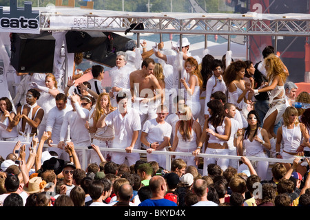 Group of young ravers dressed up in white clothes dancing on a Love Mobile near Quai Bridge, Street Parade (the most attended te Stock Photo