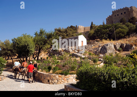 Tourists riding on donkeys to Acropolis, Lindos, Rhodes, Greece Stock Photo