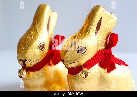 Chocolate easter bunnies wrapped in gold foil with a red ribbon and a little bell