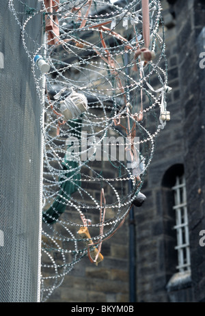 Razor wire fence, with packages caught in it thrown from cell windows, at HM Prison Leeds, Armley, Leeds, West Yorkshire, UK. Stock Photo
