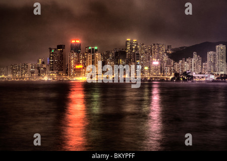 Tall buildings on Hong Kong Island city centre as seen across the harbour from Tsim Sha Tsui on Kowloon side at night Stock Photo