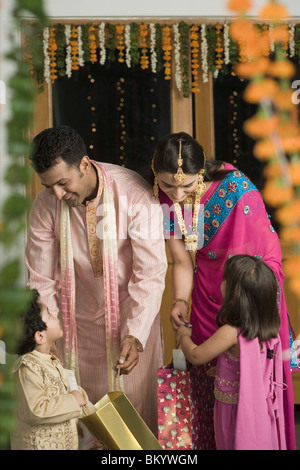 Parents giving Diwali gifts to their children Stock Photo