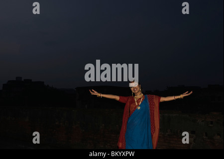 Woman standing on a terrace with arms outstretched Stock Photo