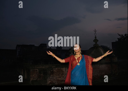 Woman standing on a terrace with arms outstretched Stock Photo