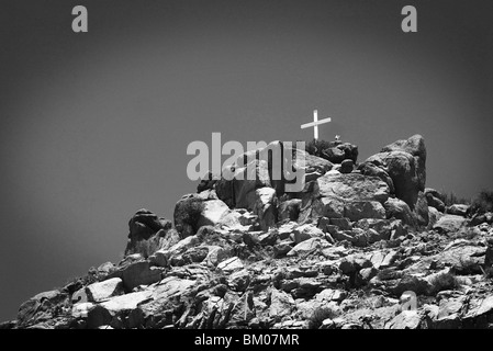 cross sits on top of a sandia mountain boulder mound landscape in black and white, along route 66, albuquerque, new mexico Stock Photo