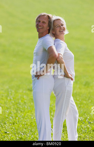 Couple standing back to back Stock Photo