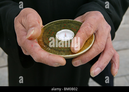 Chinese Feng Shui compass, a Lopan, in hands of Fengshui master, China, Asia Stock Photo