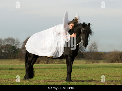 angel and friesian horse Stock Photo