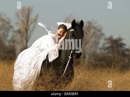 angel and friesian horse Stock Photo