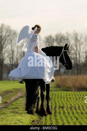 angel and friesian horse Stock Photo