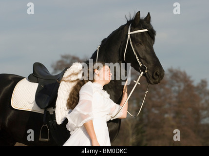 angel and friesian horse Stock Photo