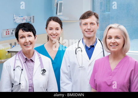 Two doctors standing with two nurses and smiling Stock Photo