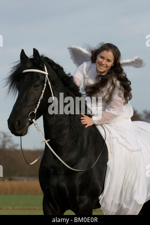 angel and friesian horse Stock Photo