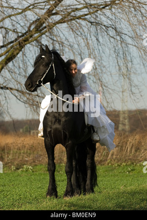 angel and friesian horse Stock Photo