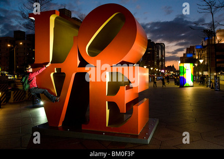 LOVE art installation in front of skyscraper Taipei 101, young German woman climbing on huge letters, Taipei, Republic of China, Stock Photo