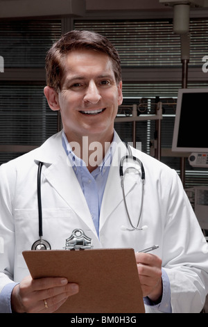 Doctor holding a clipboard and smiling Stock Photo