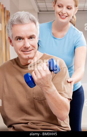 Physiotherapist assisting a patient in exercising Stock Photo