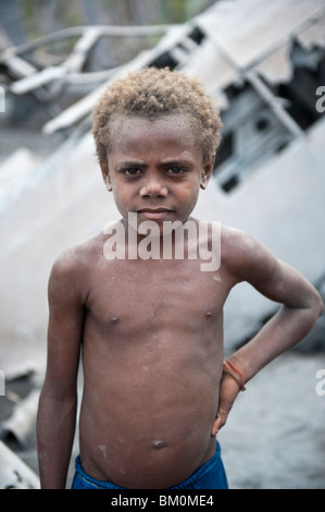 Portrait of a Young Boy Playing by the Wreckage of a WWII Japanese Mitsubishi G4M Betty Bomber Rabaul, Papua New Guinea. Stock Photo