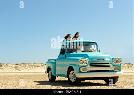 5 young people traveling in pickup truck Stock Photo