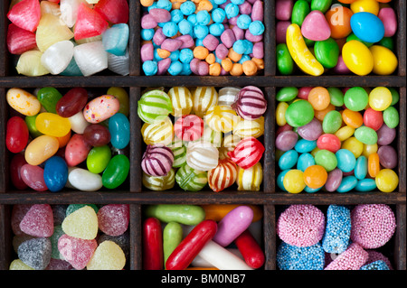Colourful assorted childrens sweets and candy in a wooden tray Stock Photo