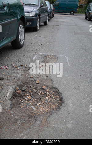 Pot holes marked for repair in a suburban road in Hounslow, Middx, UK. May 2010. See BM0Y2M  for repaired view. Stock Photo