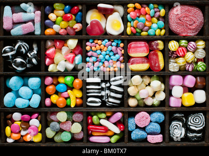 Colourful assorted childrens sweets and candy in a wooden tray