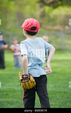 Four and 1/2 year old Hispanic boy participates in his first T-ball practice. Stock Photo
