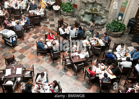looking down on diners enjoying ambiance of soaring skylit center court of Sanborns House of Tiles restaurant Mexico City Stock Photo