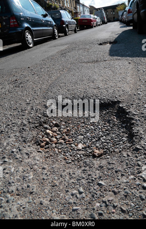 Close up of a pot hole in a suburban road in Hounslow, Middx, UK. May 2010  See BM0R6P for repaired road. Stock Photo