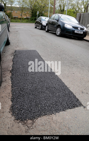 Repaired pot hole in a suburban road in Hounslow, Middx, UK. May 2010. See BM0PYF & BM0R09 for pre-repair view of this pot hole. Stock Photo