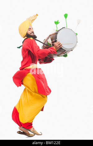 Man performing Bhangra dance with a dholak Stock Photo