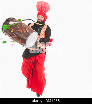 Man performing Bhangra dance with a dholak Stock Photo