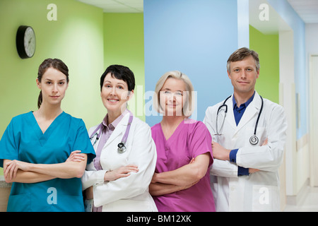 Two doctors standing with two nurses and smiling Stock Photo