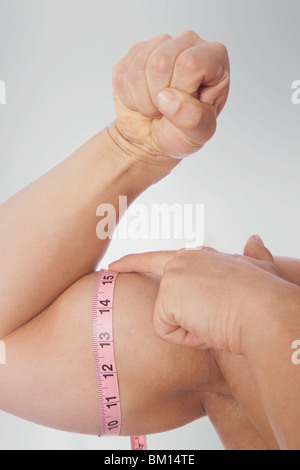Image of muscular man measure his biceps with measuring tape in centimeters  Stock Photo - Alamy