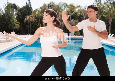 Couple exercising at the poolside Stock Photo