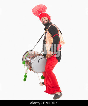 Man performing Bhangra dance with a dholak Stock Photo