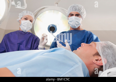 Two surgeons operating a patient in an operating room Stock Photo