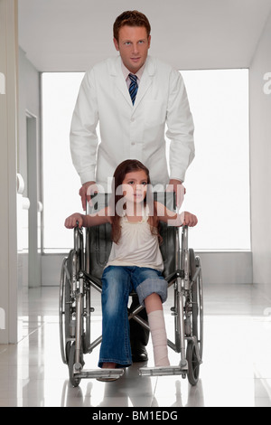 Doctor pushing a patient in a wheelchair Stock Photo