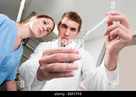 Lab technicians analyzing a sample in a test tube Stock Photo