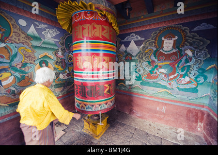 A woman spinning prayer wheel, Chimi Lhakhang dating from 1499, Temple of the Divine Madman Lama Drukpa Kunley, Punakha, Bhutan Stock Photo