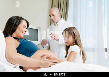 Smiling doctor examining little girls feet Stock Photo 
